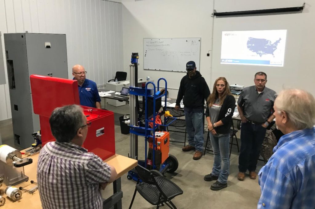 Group in workshop discussing machine tools.