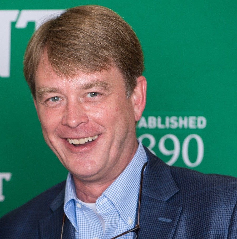 Smiling man in suit against green background
