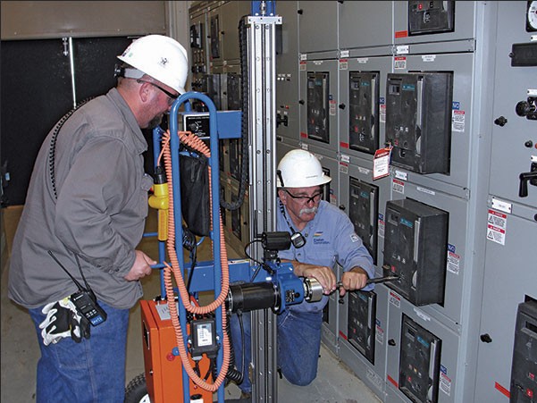 Technicians working on electrical switchgear maintenance.