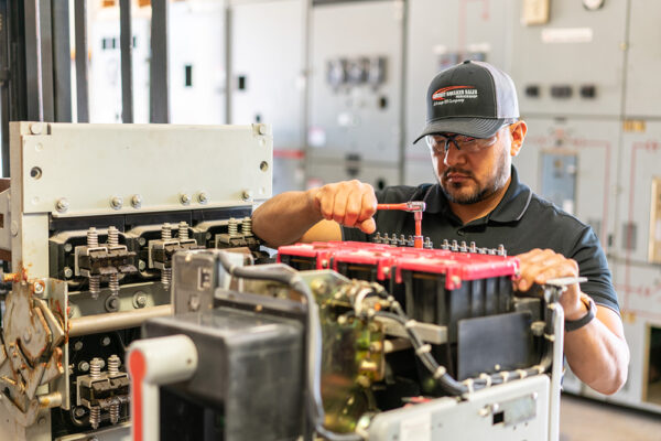 Circuit Breaker Sales service technician in front of switchgear